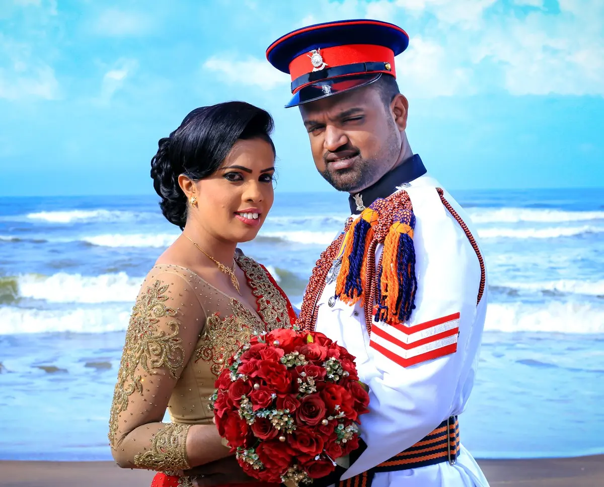 Happy couple embracing on sandy beach during romantic beach wedding shoot