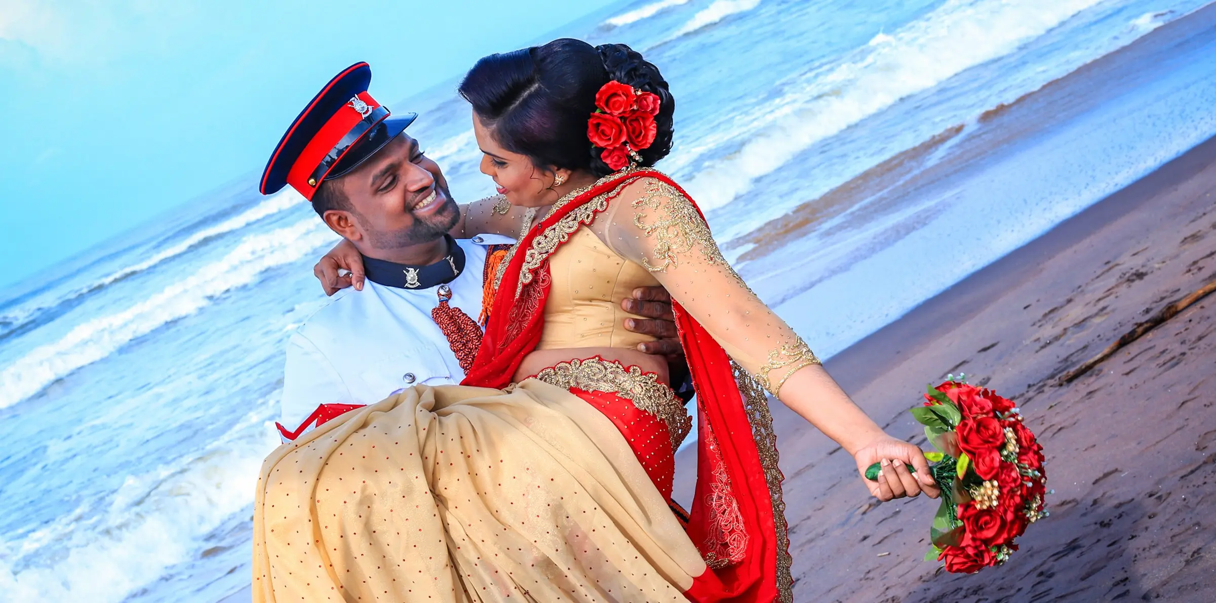 Groom lifting bride in his arms on the beach