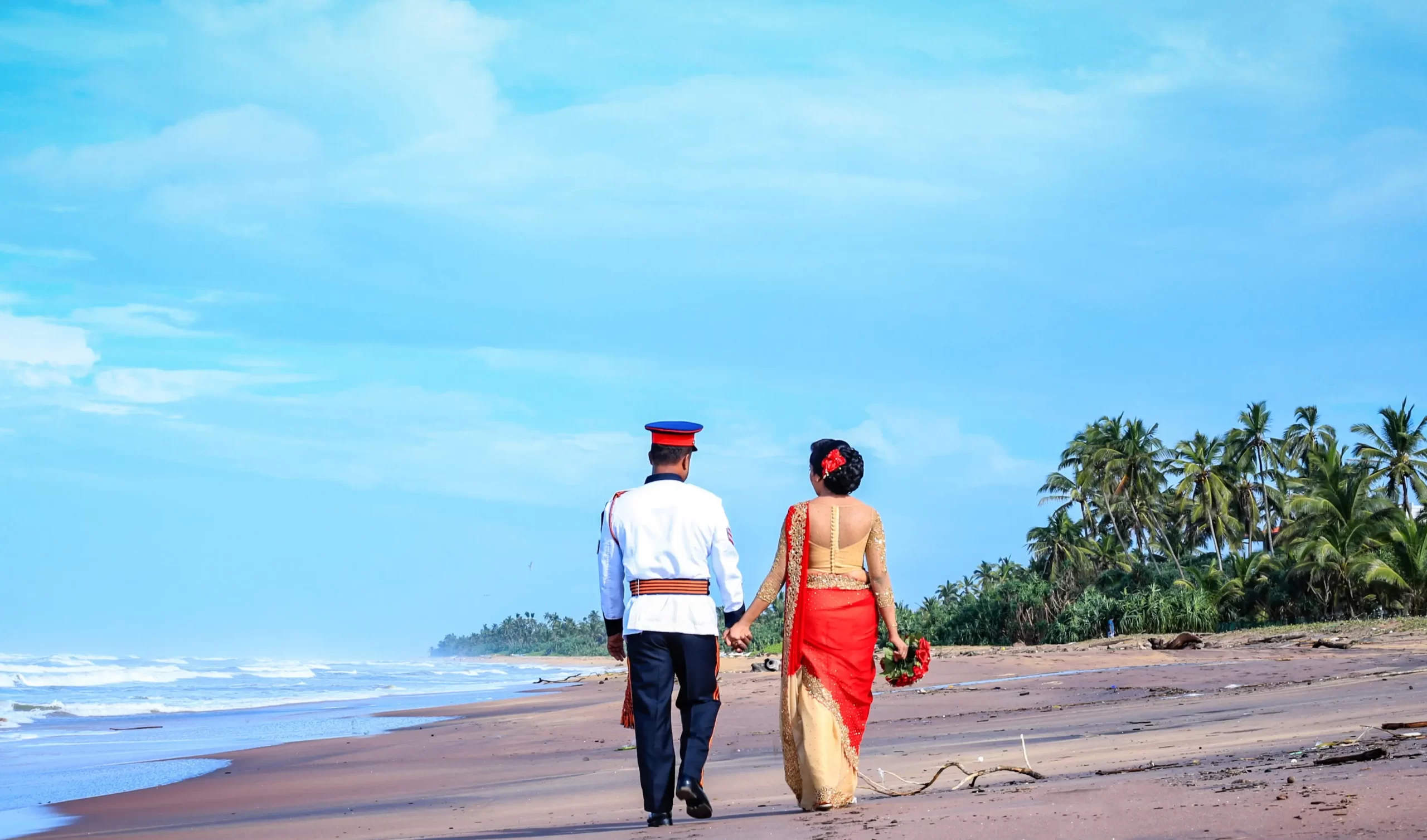 Bride and groom gazing at the horizon, hand in hand