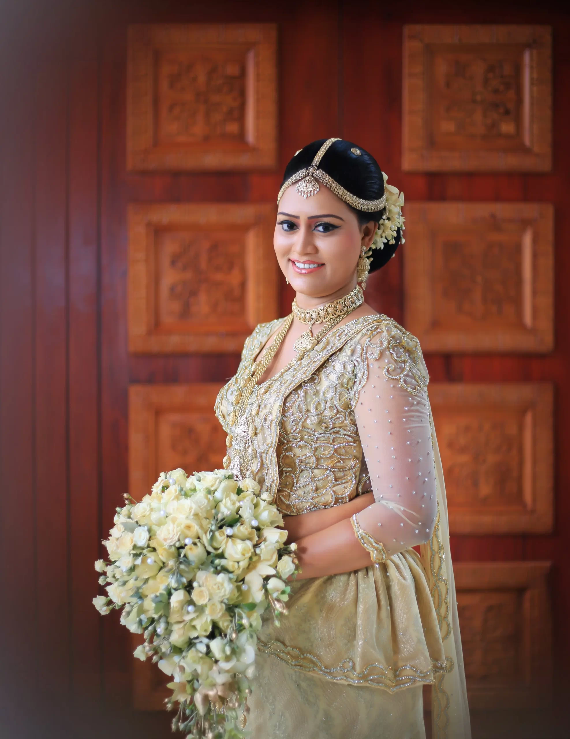 Bride in traditional Kandyan attire with gold jewelry