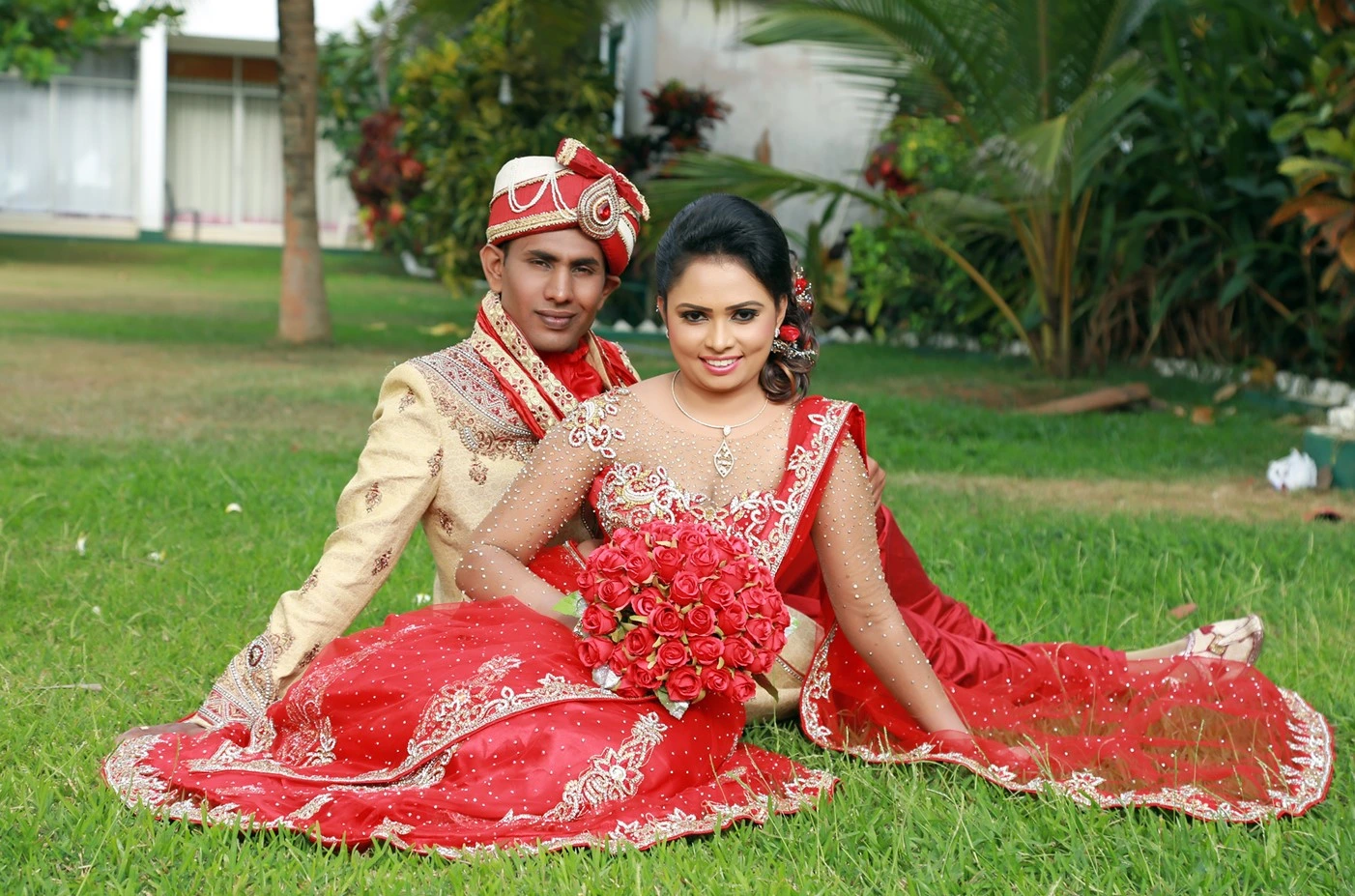 Sri Lankan couple in Indian fashion attire, girl donned in an exquisite red saree.