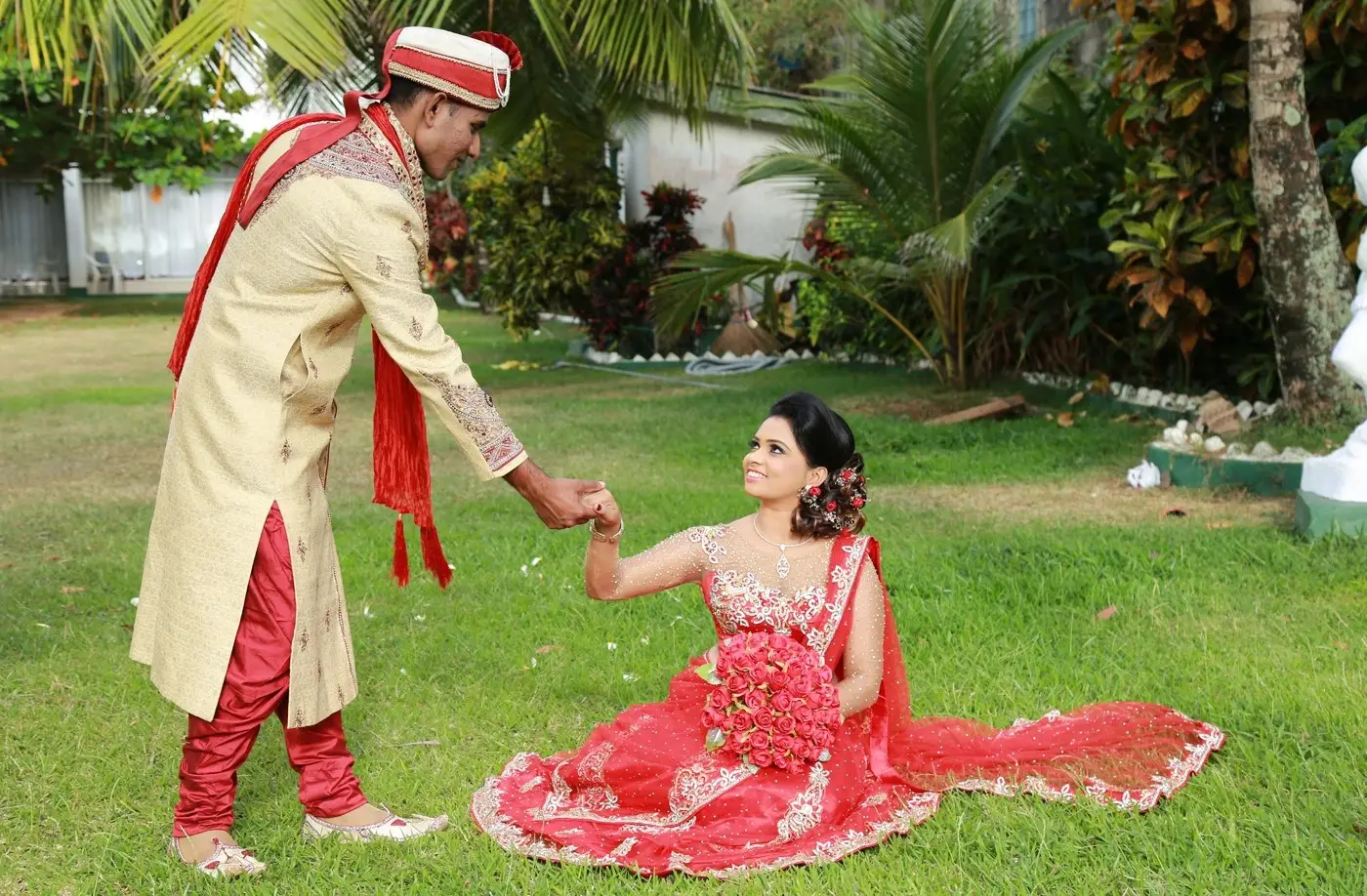 Indian-inspired wedding attire: Sri Lankan couple, girl graced in a radiant red saree.