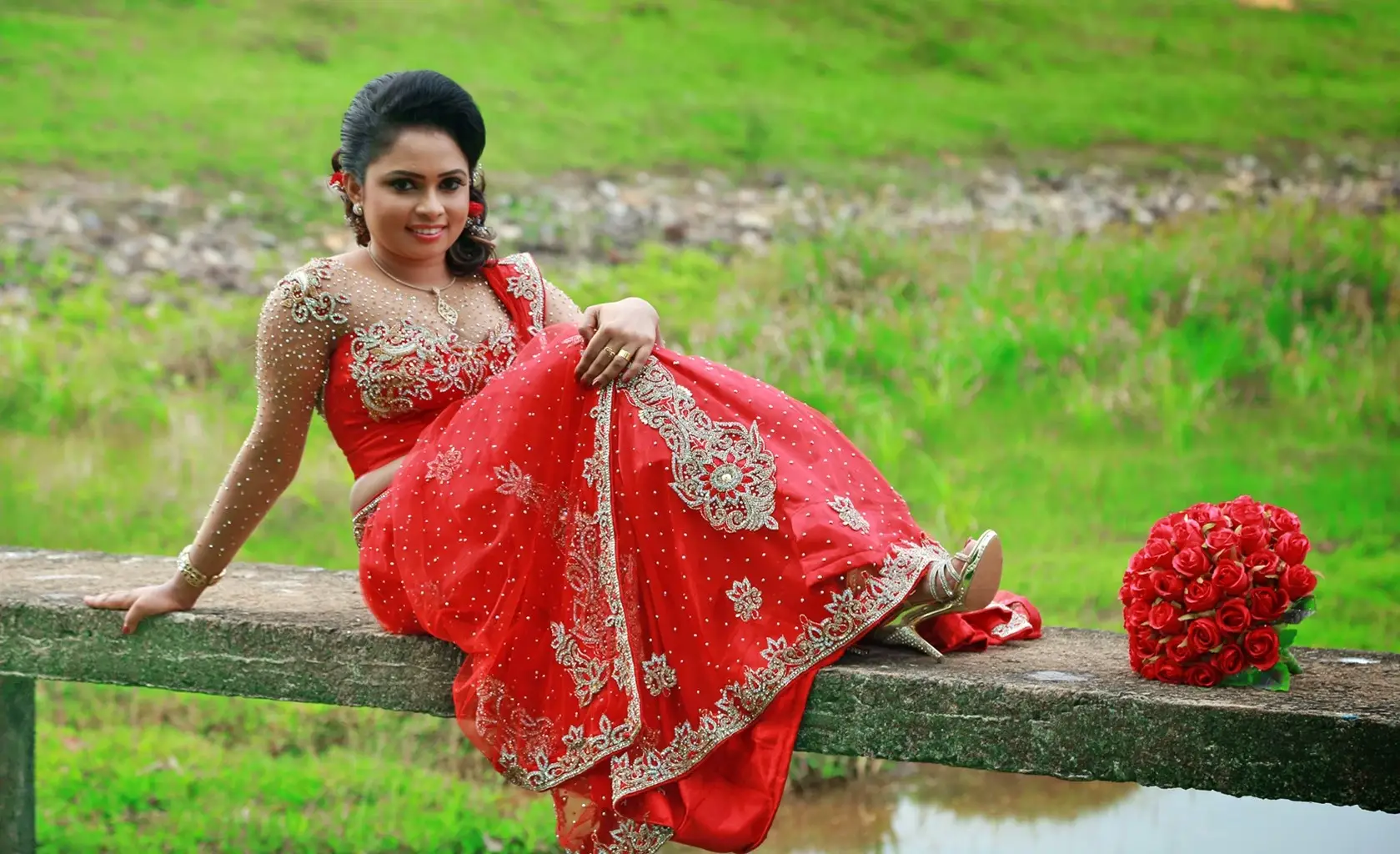 Sri Lankan couple in Indian-inspired wedding attire, girl adorned in a red saree.