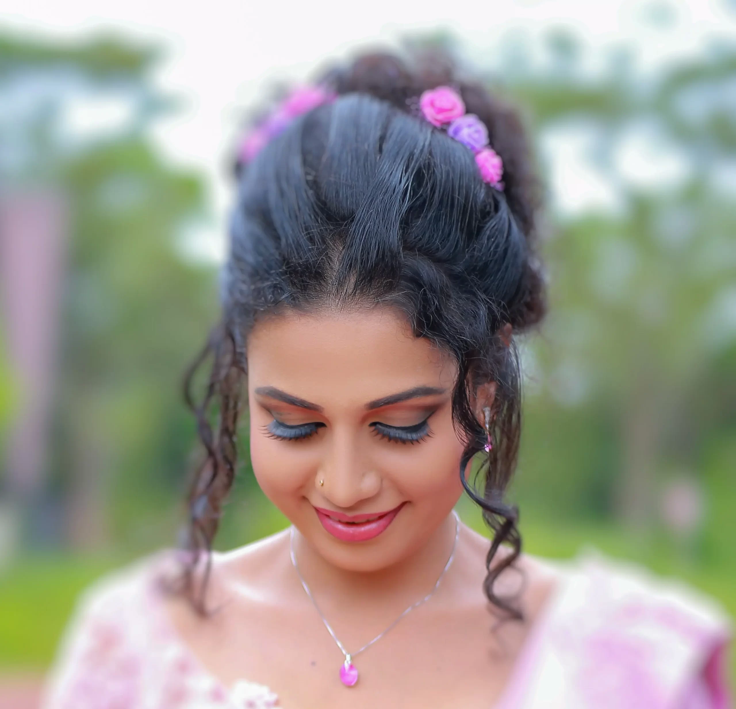 Bride looking back over her shoulder with a smile in a green environment.