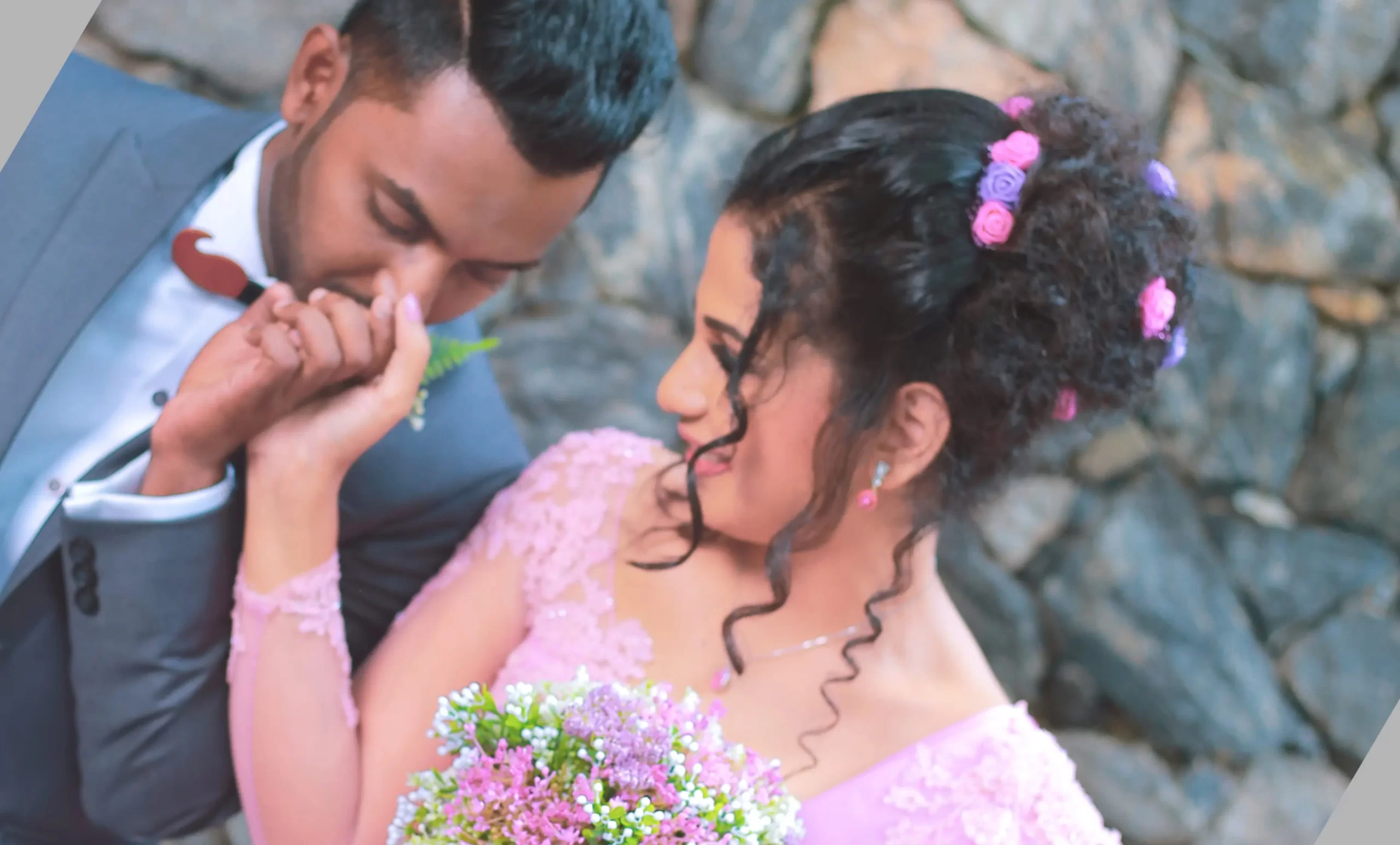 Groom adjusting his bowtie in a natural green setting.