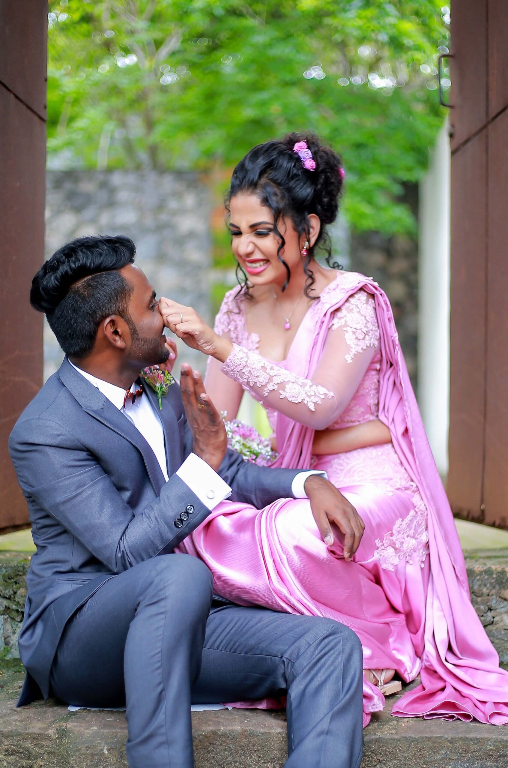 Bride and groom looking at each other lovingly in a lush green outdoor environment.