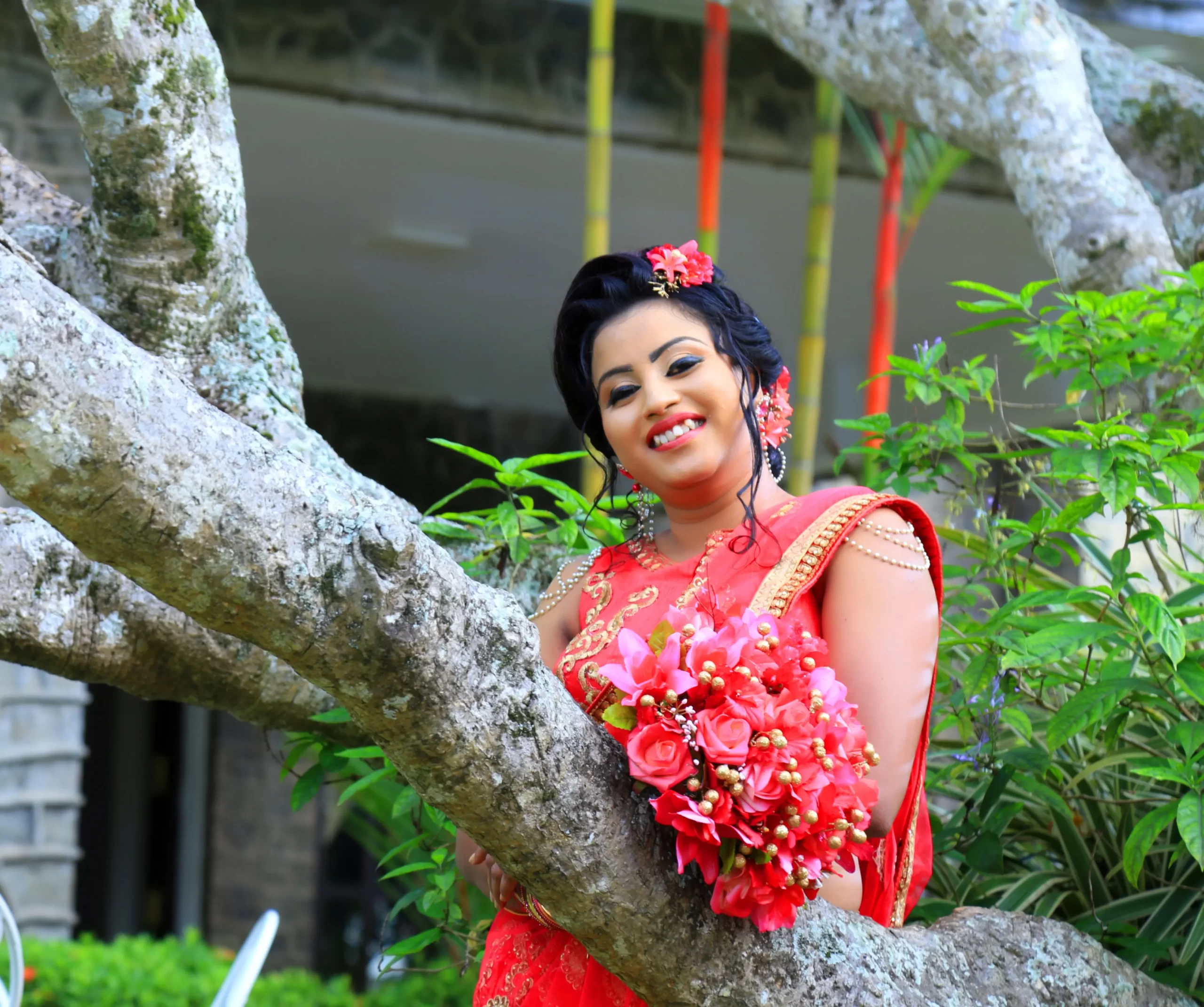 Bride in Indian sherwani standing under a tree