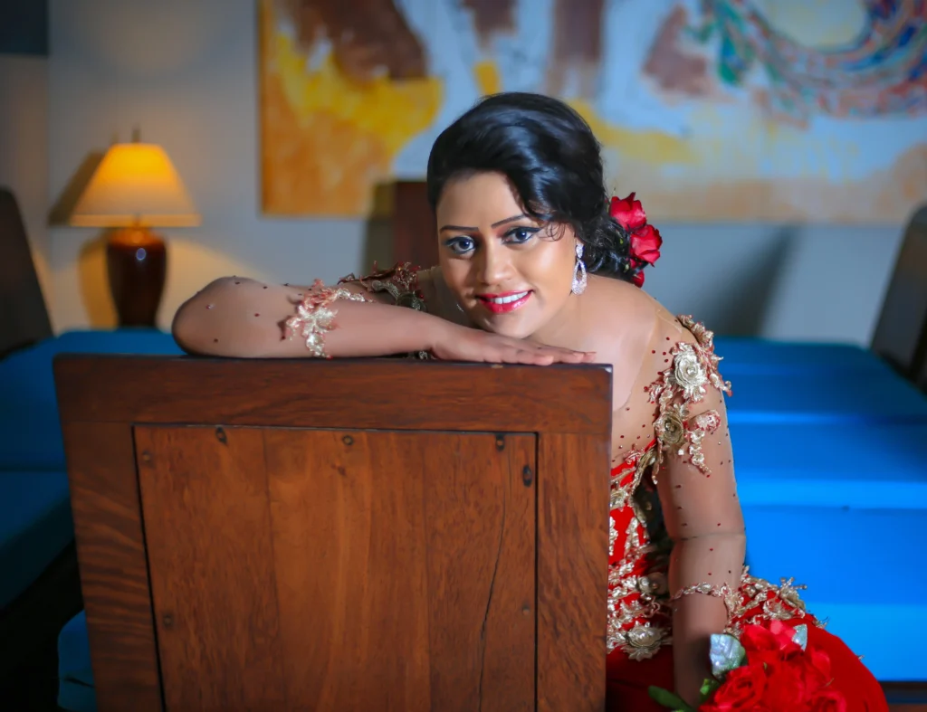 Bride in a red dress with a bouquet of flowers during an indoor homecoming wedding shoot.