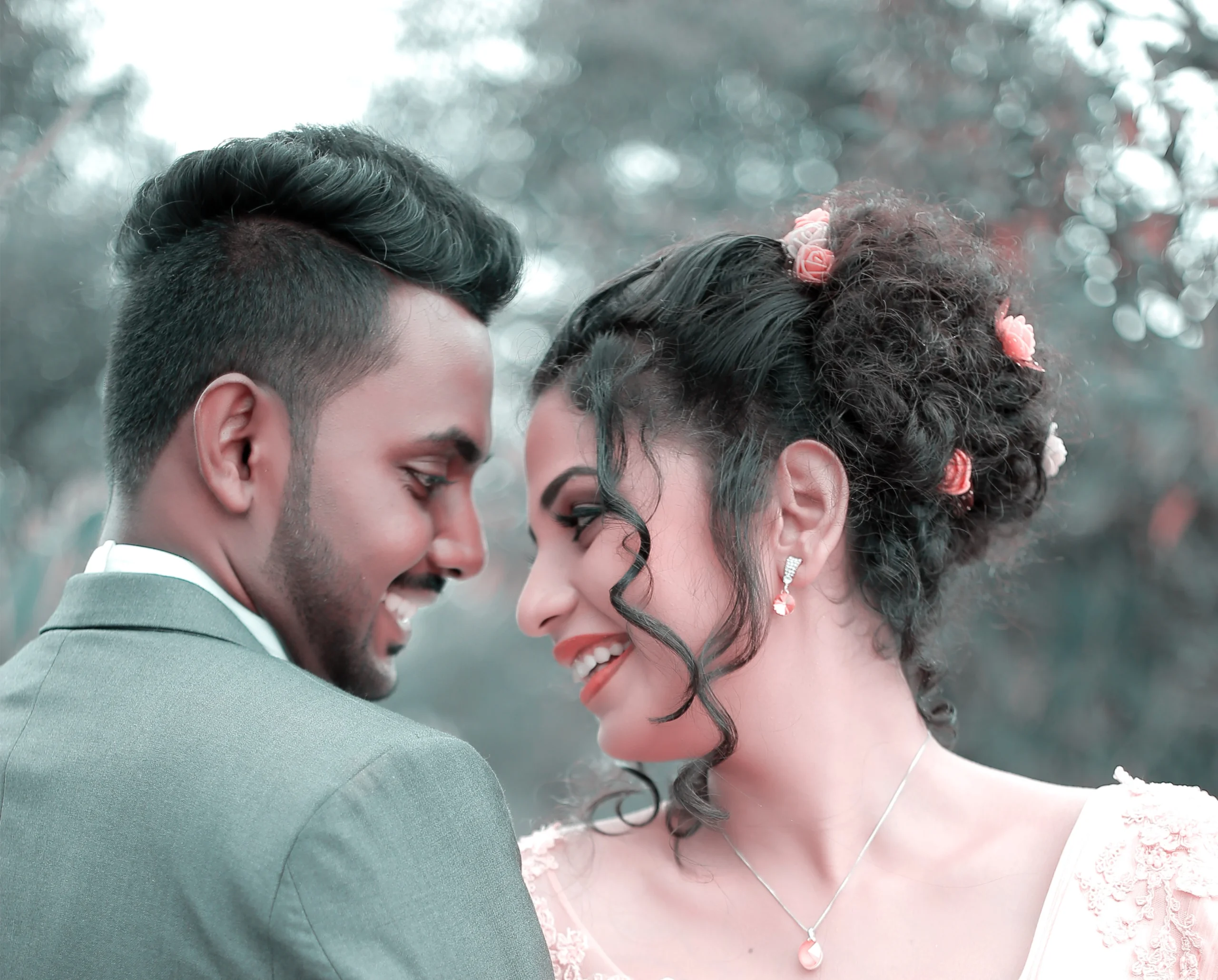 Bride and groom sharing a kiss under a tree